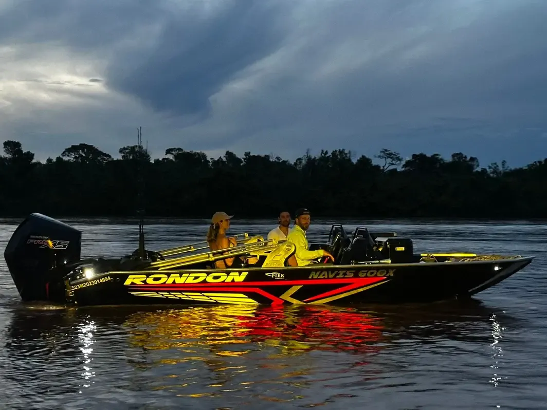 Barco de pesca Navis 600X com amigos a bordo navegando no rio ao entardecer
