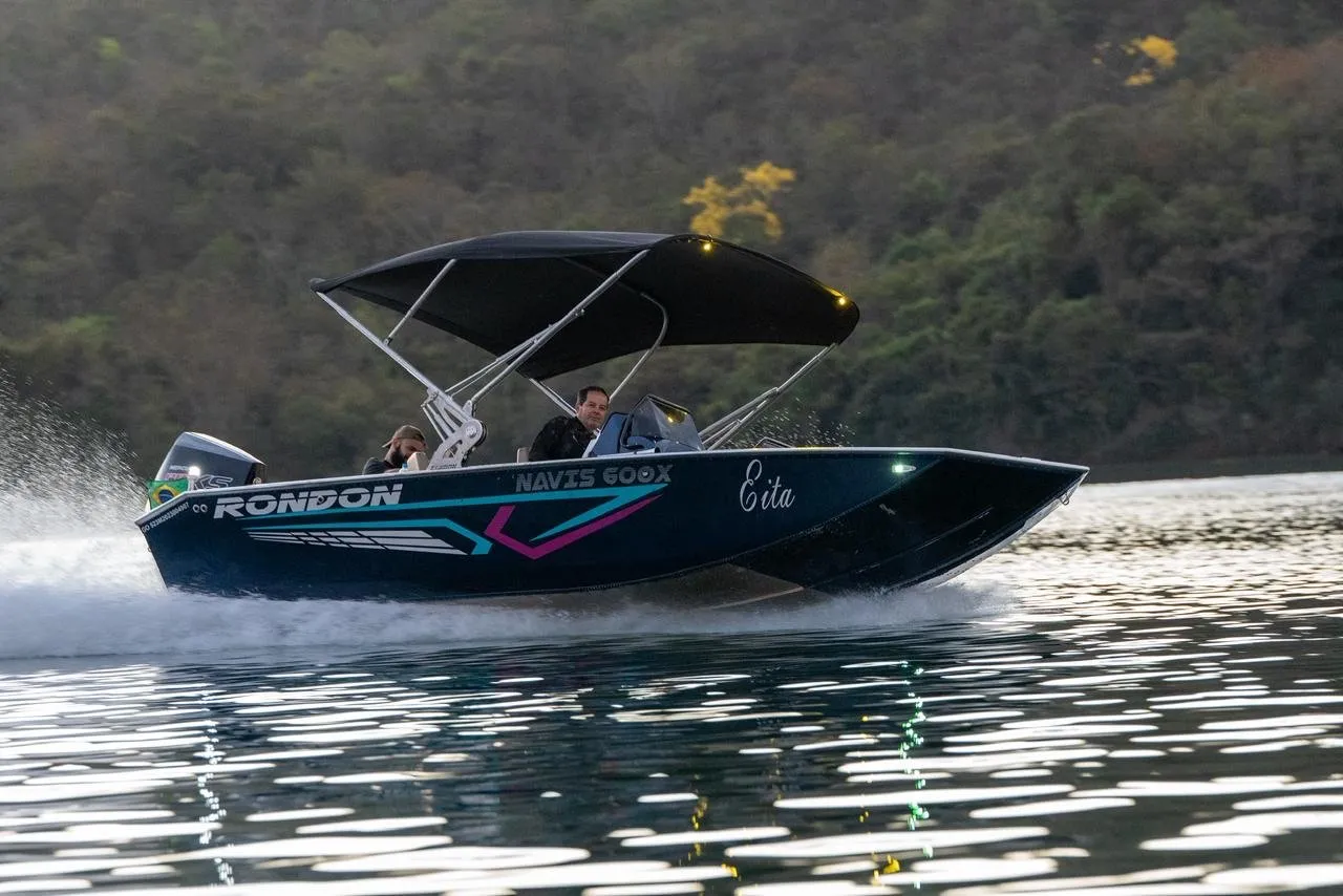 Navis 600X azul com toldo navegando no lago, vista lateral