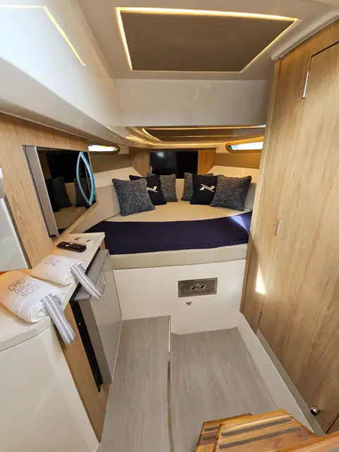 Cabine com cama de proa, TV, micro-ondas e geladeira